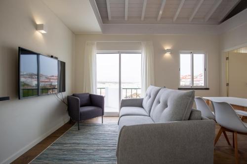 a living room with a couch and a tv at Casa da Rocha in Baleal
