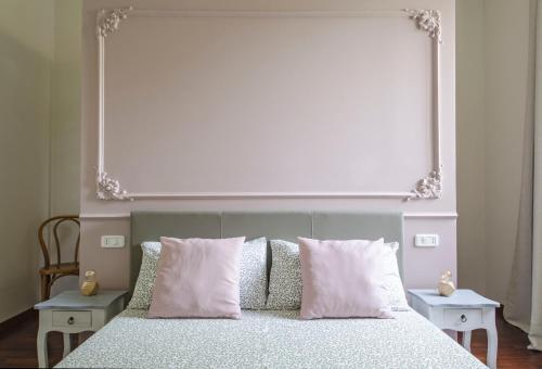 a bed with pink pillows and a large window above it at Bramante 21 in Pesaro