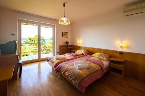 a bedroom with a bed and a large window at Old Road Rooms and Apartments with Pool in Portorož