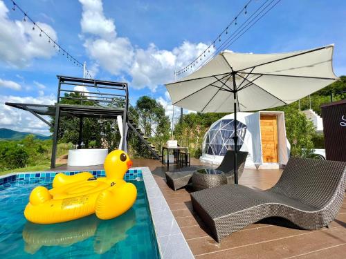 a swimming pool with two rubber ducks in the water at เคียงดาว โฮมสเตย์ แก่งกระจาน in Ban Song Phi Nong