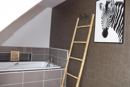 a ladder next to a bathroom with a picture of a zebra at Maison Menadel in Yvetot
