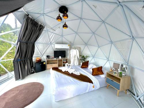 a bedroom in a dome tent with a bed and a desk at เคียงดาว โฮมสเตย์ แก่งกระจาน in Ban Song Phi Nong