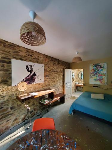 Cette chambre comprend un lit, un bureau et une table. dans l'établissement Domaine du Mas Coutant, à Sarlande