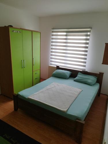 a bedroom with a bed with green cabinets and a window at Salvatori 