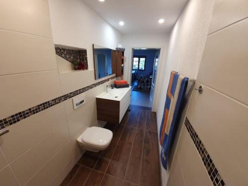 a bathroom with a toilet and a sink and a mirror at Haus Sonnenblume in Weilheim