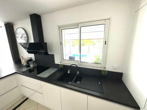 a kitchen with a sink and a window at VILLA PISCINE DE LA GARRIGUE in Florensac