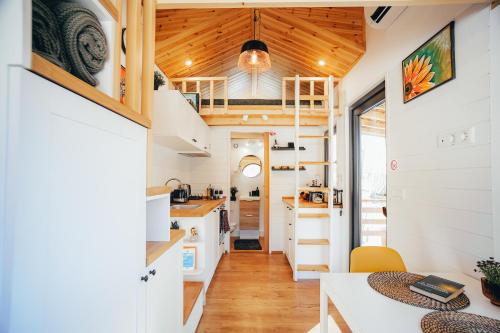 a kitchen and dining area of a tiny house at Togethernest Glamping in Mătişeşti