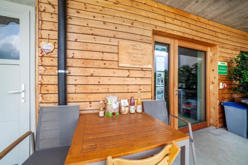 a wooden wall with a table and chairs on a patio at Langstein Wohnung Lavendel in Coldrano