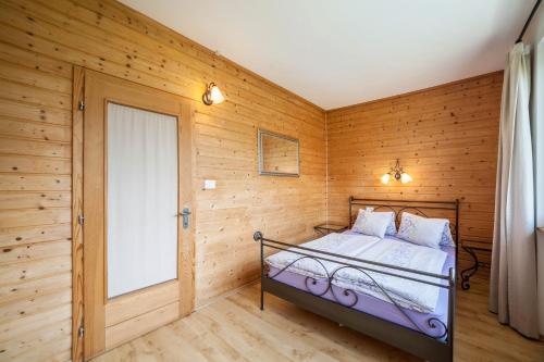 ein Schlafzimmer mit einem Bett in einer Holzwand in der Unterkunft Langstein Wohnung Lavendel in Goldrain