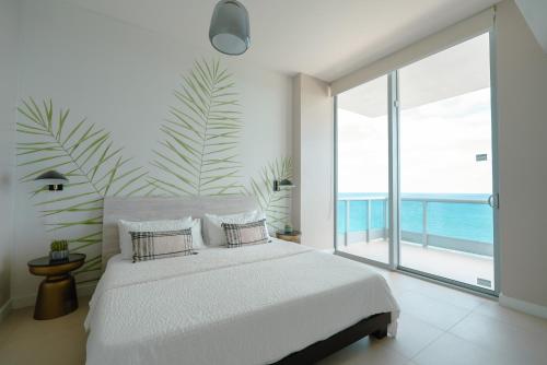 sypialnia z białym łóżkiem i dużym oknem w obiekcie Monte Carlo Miami Beach w Miami Beach