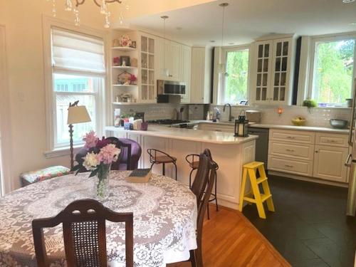 a kitchen with a table with a vase of flowers on it at Cottage on Caledonia Bed & Breakfast in Stratford