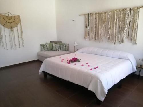 a bedroom with a large white bed with flowers on it at VILLA DEL CIELO TIXPEHUAL in Tixpehual