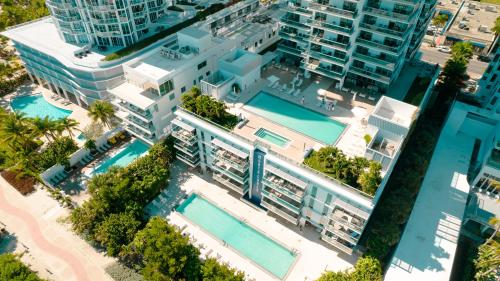 マイアミビーチにあるMonte Carlo Miami Beachの2つのスイミングプールがある建物のオーバーヘッドビュー