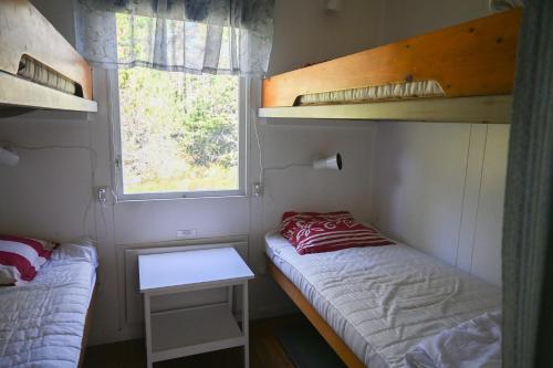 a small room with two bunk beds and a window at Rolfskärrs Stugby in Nygård