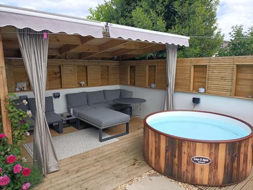 a hot tub sitting on a patio with a canopy at Greenfields Spa with private hottub New listing in Malvern Link