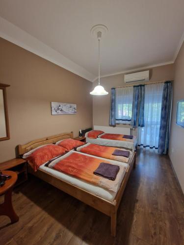 una camera con 2 letti con cuscini rossi di Villa Letícia Siófok a Siófok