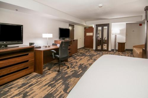 a hotel room with a bed and a desk and a television at Fairfield Inn & Suites by Marriott Dallas DFW Airport South/Irving in Irving