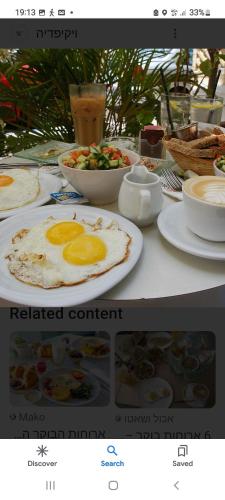 a table with a plate of food with eggs on it at Heleni Hotel in Jerusalem