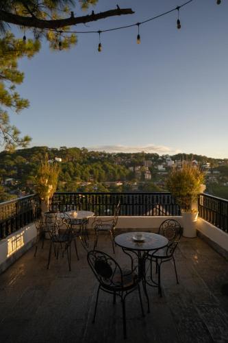 a patio with tables and chairs on a balcony at Moon Valley Villas Đà Lạt in Xuan An