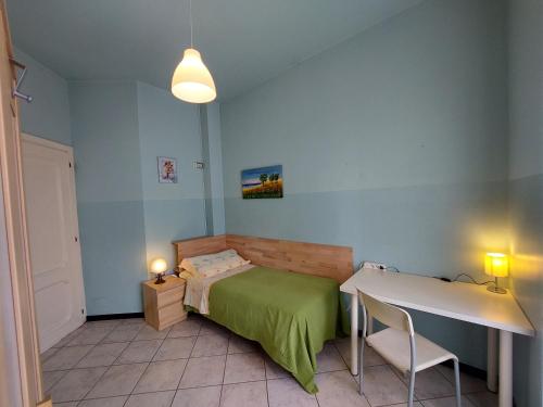 Un dormitorio con una cama verde y una mesa en Cà dell'Angelo, en Canegrate