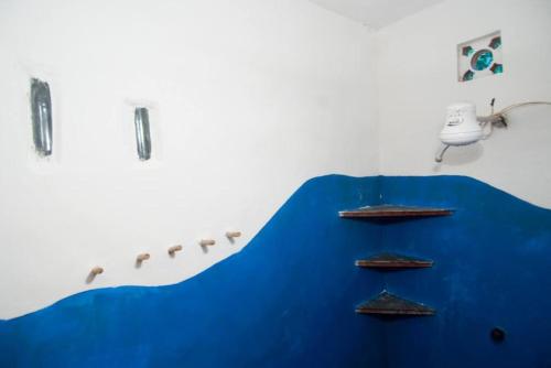 um quarto com uma parede azul com prateleiras em Canto do Morere em Morere