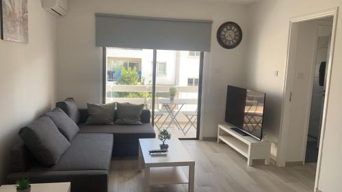 a living room with a couch and a television at Prestige Worldwide Apartments in Ayia Napa