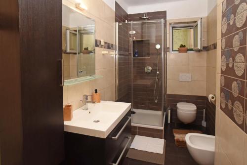 uma casa de banho com um lavatório, um chuveiro e um WC. em Apartment Toro em Split