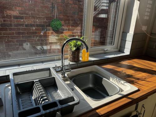 a kitchen sink with a dish drying rack next to a window at The Gladstone terrace in Chester