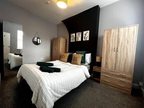 切斯特的住宿－The Gladstone terrace，一间卧室配有一张带白色床单和绿色枕头的大床。
