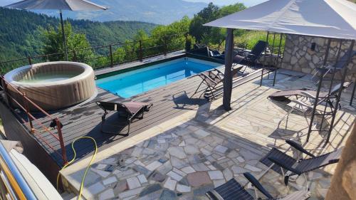 a deck with a pool and chairs and an umbrella at Villa unforgettable in Sarajevo