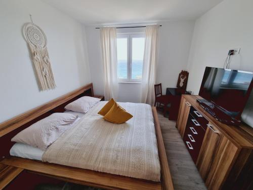 1 dormitorio con 1 cama, TV y ventana en Apartment Mara, en Senj
