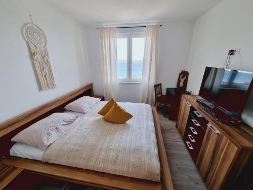 a bedroom with a bed and a tv and a window at Apartment Mara in Senj