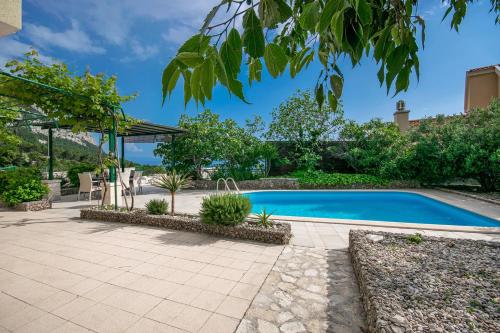 a swimming pool in a yard with a patio at Villa Marino in Makarska, private pool in Makarska