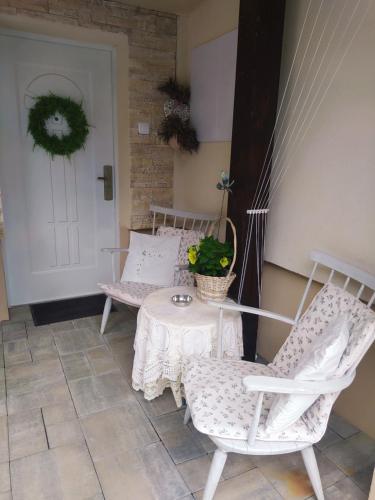 a porch with two chairs and a table with a plant at Apartmán Karin in Huty
