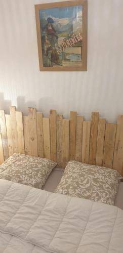 une chambre avec un lit avec une tête de lit en bois dans l'établissement Appartement au pied des télécabines Res La Soulan, à Luchon