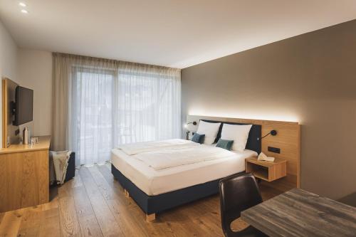 ein Schlafzimmer mit einem großen Bett und einem Tisch in der Unterkunft Residence Nives in Brixen
