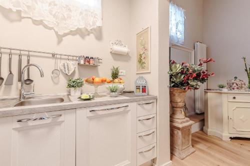 a kitchen with white cabinets and a sink at CASA UCCELLINI with a Romantic Terrace in Lucca