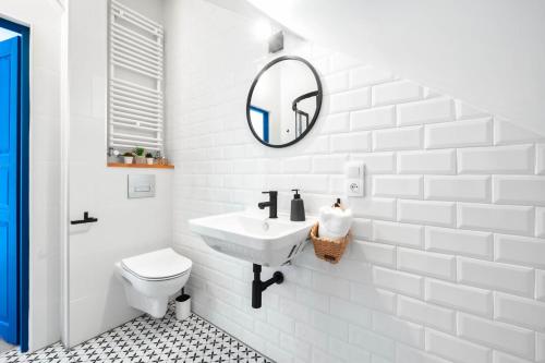 uma casa de banho branca com um lavatório e um espelho em Apartament na Jezuickiej em Lublin