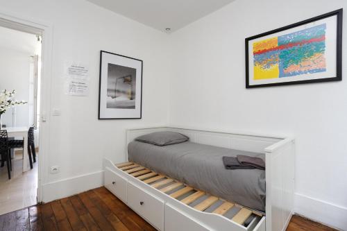 ein Schlafzimmer mit einem Bett mit einem ausziehbaren Regal in der Unterkunft F1 Jean Jaurès 3G in Aubervilliers