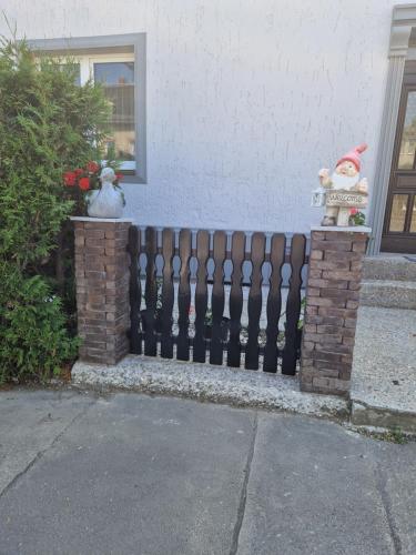 a fence in front of a house with a santa hat at Pension Valentina in Mühlau