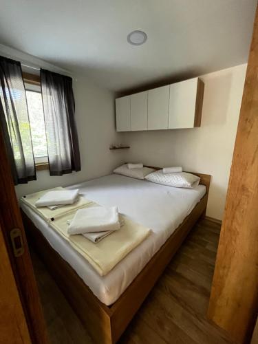 - une chambre avec un grand lit blanc et des armoires blanches dans l'établissement Lily B, à Pakoštane