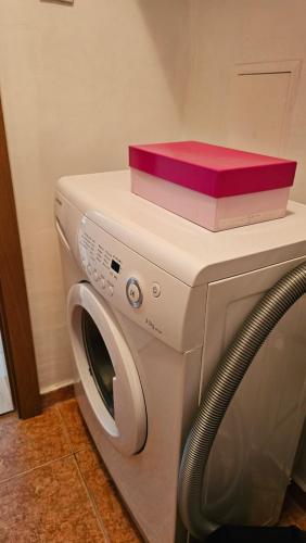 een witte wasmachine met een rode doos erop bij Complex Top Apartment in Sveti Vlas