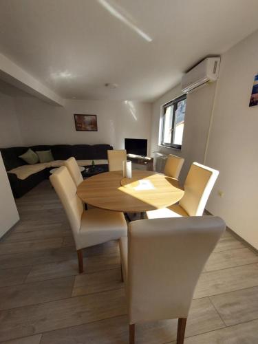 Apartman Trupsi في يايتشه: غرفة طعام مع طاولة وكراسي خشبية