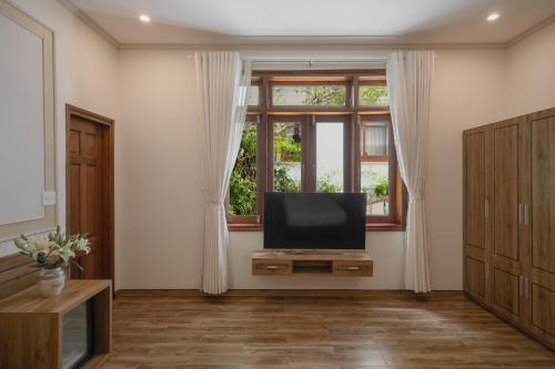 a living room with a tv and a window at Moon Valley Villas Đà Lạt in Xuan An