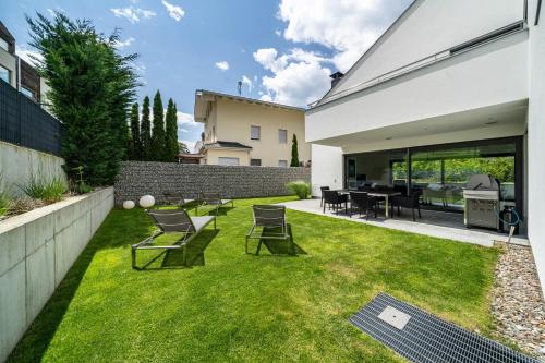 a backyard with a lawn with chairs and a table at Villa Shangrila in Naturno