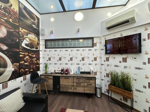 a bathroom with a sink and a tv on a wall at Хотел АВРОРА in Haskovo