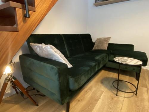 a green couch in a living room with a table at Apartament Schodami do Nieba in Bytom