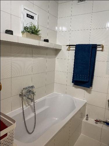 a bath tub in a bathroom with a blue towel at Apartament Schodami do Nieba in Bytom