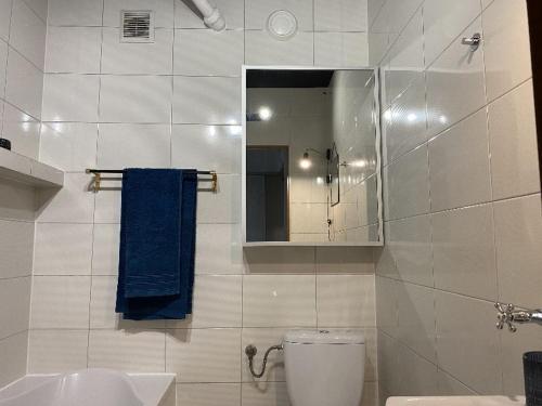 a bathroom with a toilet and a sink and a mirror at Apartament Schodami do Nieba in Bytom