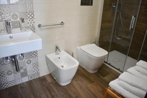 a bathroom with a toilet and a sink and a shower at Domus Solis in Pachino